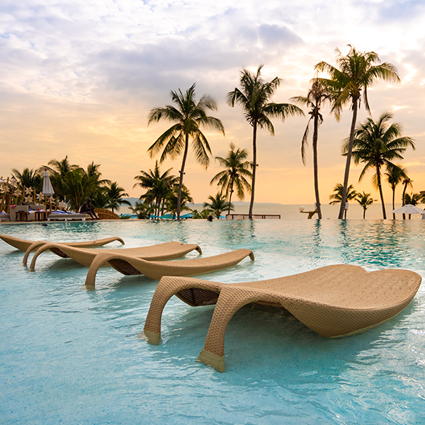 image of resort pool with chaise lounge chairs and palm trees